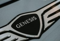 aap-best-car-logos-and-their-hidden-meanings-1790771816 Detailed close-up of the Genesis car logo emblem for automotive branding.